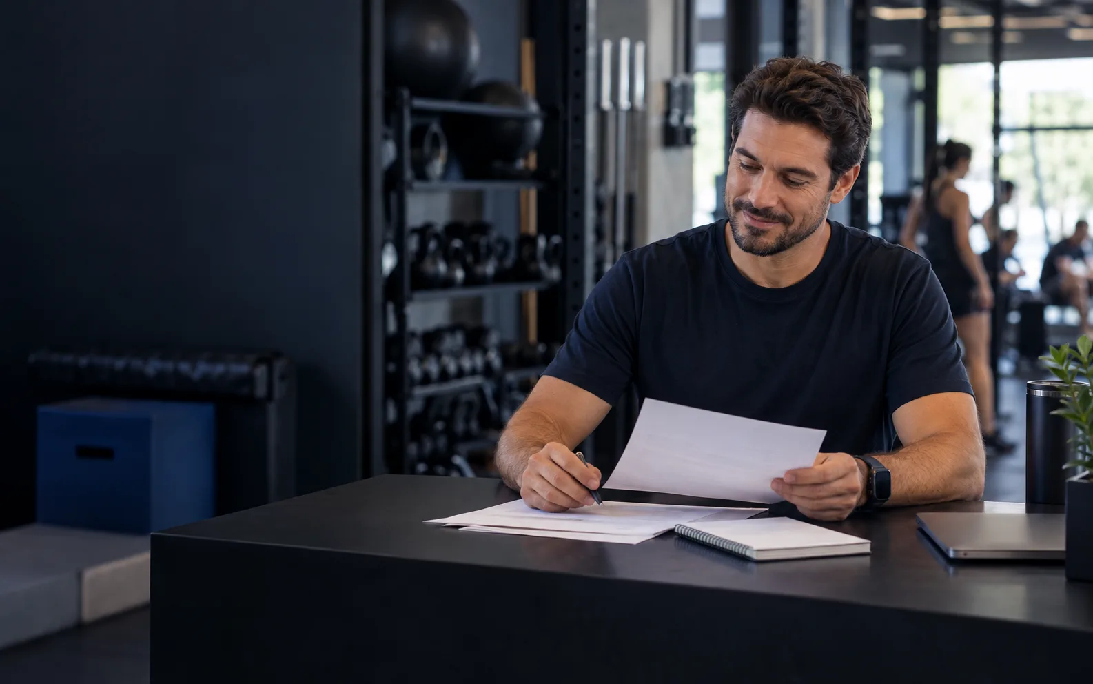 Gestor de um espaço fitness revisando documentos financeiros em uma mesa